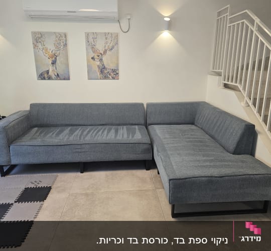 ספות אפורות ליד גרם מדרגות עם תמונות קיר